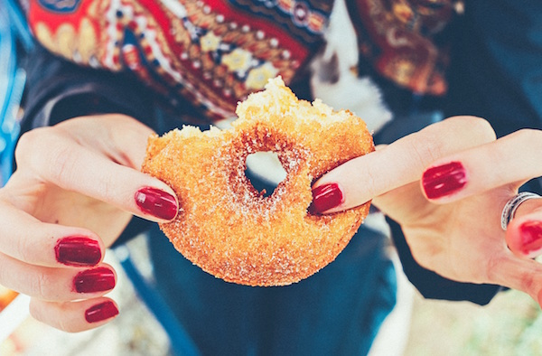 woman holding a sugar doughnut