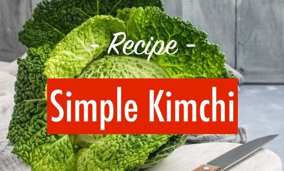 Whole savoy cabbage on a chooping board beside a sharp knife - prepeare to make homemade kimchi